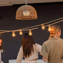 Group of women standing on a wooden deck with string lights and lanterns.