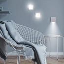 Modern interior with a wire chair and gray blanket against a gray wall.