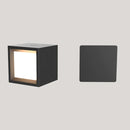 Black square wall light with a glowing interior on a gray background