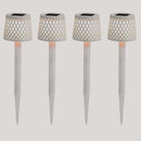 Four solar-powered garden lights on with lattice designs on white ground spikes on a white background