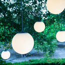 String of spherical outdoor lights hanging among trees, portable lights that are rechargeable