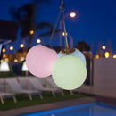 Colorful outdoor string lights hanging over a pool area at night. Portable lights that are rechargeable