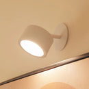 White wall-mounted light fixture on a beige wall