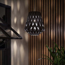 Black Wooden Pendant Light by Pilke at night casting light patterns on the wooden panelling