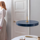 Blue Umage Asteria Pendant Light above a table with a women looking out of a window in the background