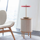 Umage Asteria Table Lamp in Rose on a Side Table next to an Umage Chair