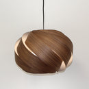 Nuez Laminate Wooden Lampshade by Shropshire Shades on a pendant light against a plain background 

