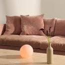 Rose Coloured Halo Design Candy Ball Table Lamp on a coffee Table in front of a dusky pink sofa