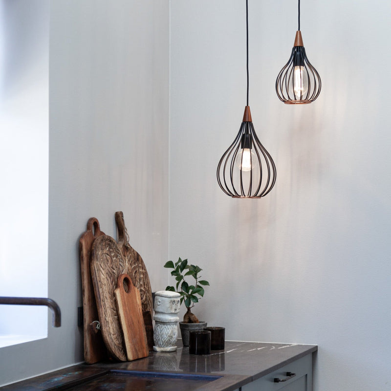 Modern kitchen with pendant lights, wooden cutting boards, and a plant.