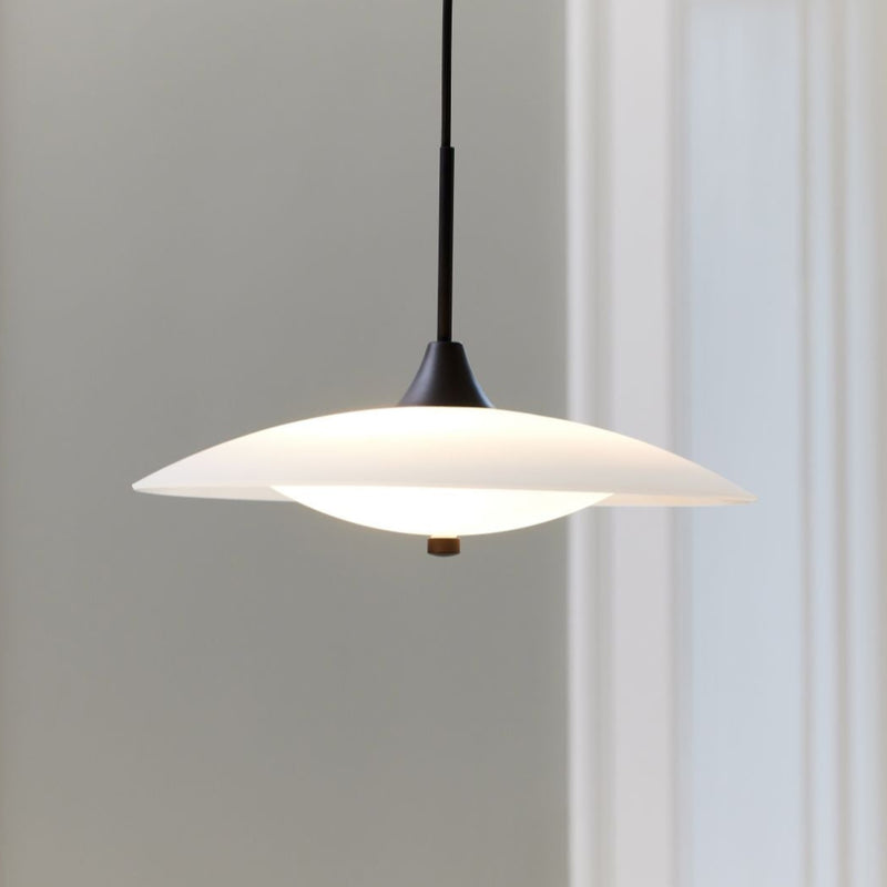 Pendant light with white shade and black fixture on a neutral background
