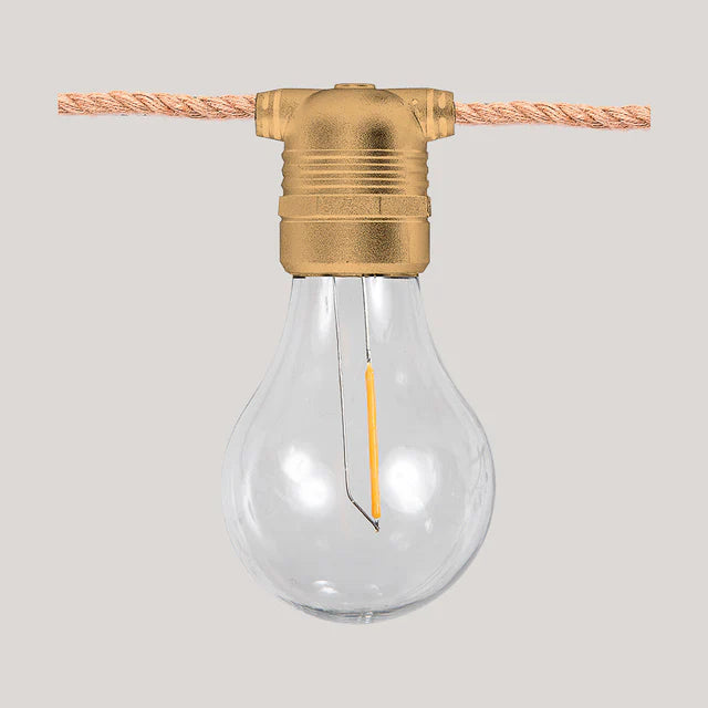 Clear light bulb with brass fitting on a gray background