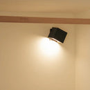 Black wall-mounted light fixture on a beige wall