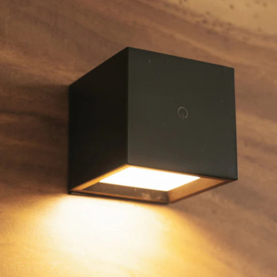Black square wall light fixture on a textured wall