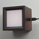 Small square light with USB connection held in a hand