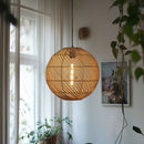 Rattan Globe Lampshade by Shropshire Shades in front of a window 