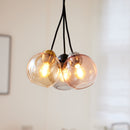 Close-up of Halo Design Bubbles glass pendant lights in amber, rose and smoke, 14cm sphere glass pendants