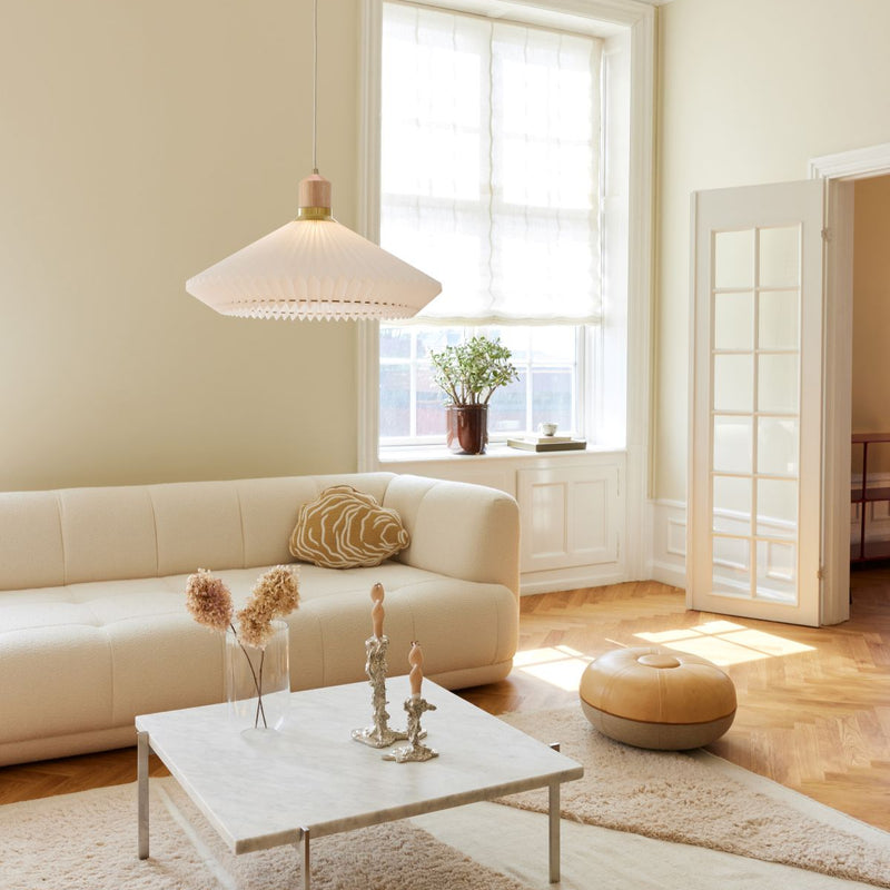 Modern living room with a beige sofa, coffee table, and decorative items.