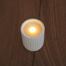 White textured candle on a wooden surface