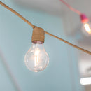 Edison bulb hanging from a rope against a light blue background