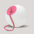 White ball with a pink suction cup and rope on a light gray background