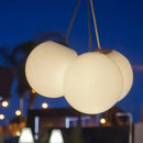 Three illuminated spherical pendant lights hanging against a night sky. Portable lights that are rechargeable