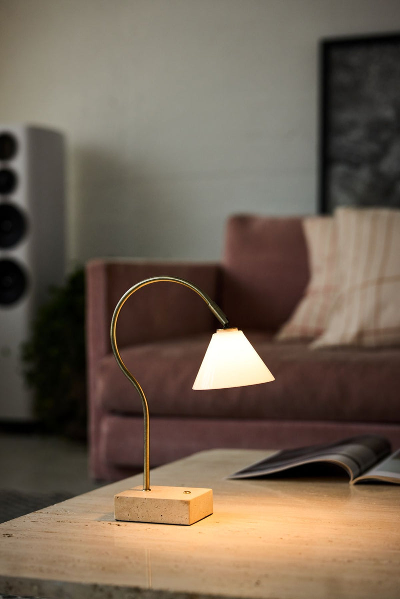 Table lamp on a wooden surface with a blurred background of a living room.