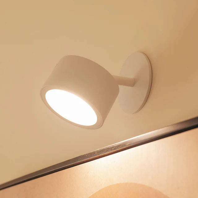 White wall-mounted light fixture on a beige wall