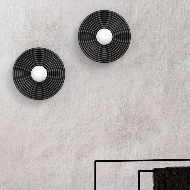 Robin Lamps Randa Mono Wall Light in Black and Opal mounted on textured grey wall