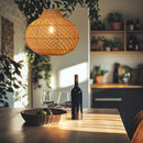 Thatch Jar Rattan Lamp shade above a  wooden table in a kitchen with plants giving a rustic natural feel