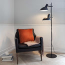 Halo Design Metropole 2-Arm Floor Lamp in Black next to chair
