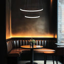 a pair of Vortex LED Ring Pendant Lights over a table  in a restaurant