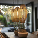 Thatch Cigar Rattan Lampshade hung in a collection of 3 over a dining table 