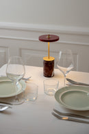 Umage Asteria Move Mini Portable Table Lamp  in Red Marble on a set dining table in a Restaurant