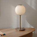 Umage Audrey Spherical Glass Table Lamp on a table with some pencils