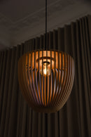 Clava Wooden Lampshade by Umage in a dark room.