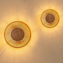 2 Clava Wall Lights by Umage casting beautiful light patterns across the wall