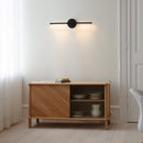 Umage Omni Wall Light in Black above a sideboard 