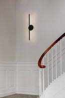 Black Umage Omni Wall Light by a staircase