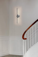Umage Omni Wall Light in Brushed Steel by a staircase