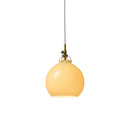 Halo Design Toscana pendant light in cream, small 18cm warm yellow glass sphere with antique brass fitting on white background