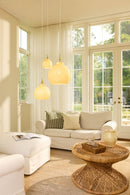 Halo Design Toscana glass pendant lights in cream in three sizes hanging above a sofa in a bright Scandinavian living room