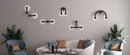 Robin Lamps Rigoberta indirect wall lights in matte black showing multiple configurations on a warm grey living room wall