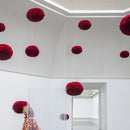 red Umage pendant lampshades hanging in a white showroom