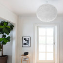 Large white Umage pendant lampshade hanging in a modern hallway