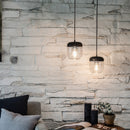  2 Black Umage Acorn Glass Lampshades against a rustic brick wall
