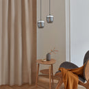 2 Smoke glass and steel Umage Acorn Glass Lampshades hanging over a small side table and chair