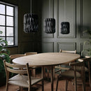  3 Pilke Signature 18 Wooden Pendant lights in black Birch above a dining table