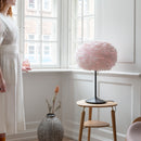 Black Sante Table lamp by Umage with a pink Feather Lampshade in a room setting