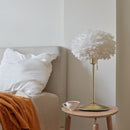 Sante Table Lamp by Umage with a EOS Feather Lampshade on a bedside table