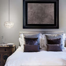 Mini EOS feather lampshade on a pendant light  hanging next to a bed.